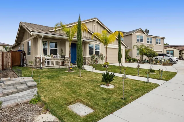 a view of a white house with a yard and plants