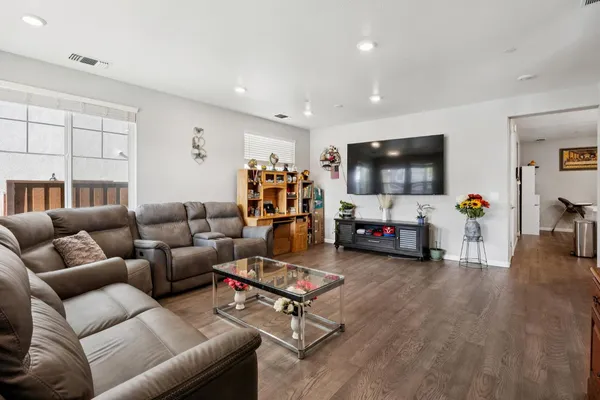 a living room with furniture and a wooden floor