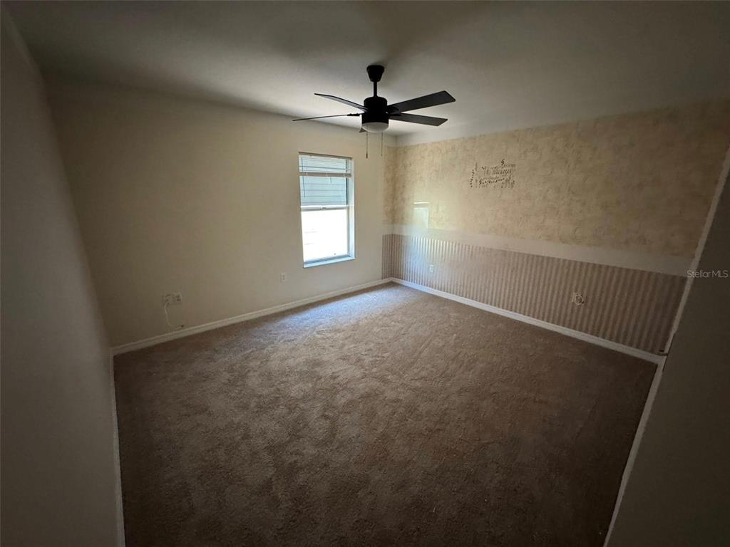 14373 Irving Street Spring Hill, FL 34609 - Photo 3 of 4 an empty room with windows and fan
