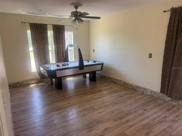 a view of room with wooden floor and fan