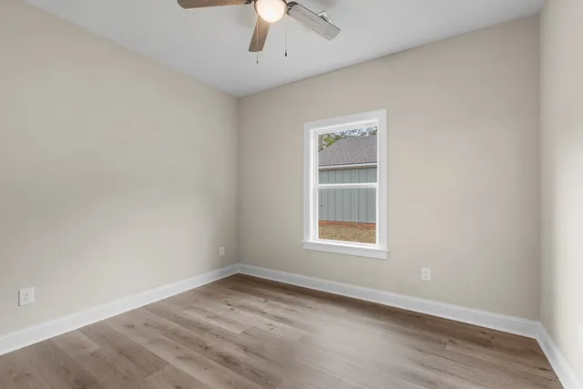 an empty room with a window and a ceiling fan