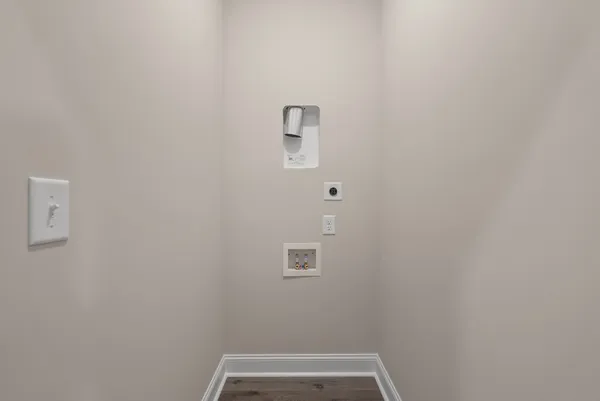an empty room with wooden floor chandelier fan and windows