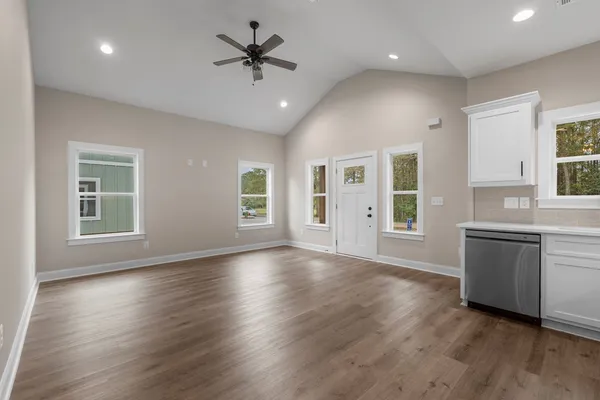 a view of an empty room with window and wooden floor