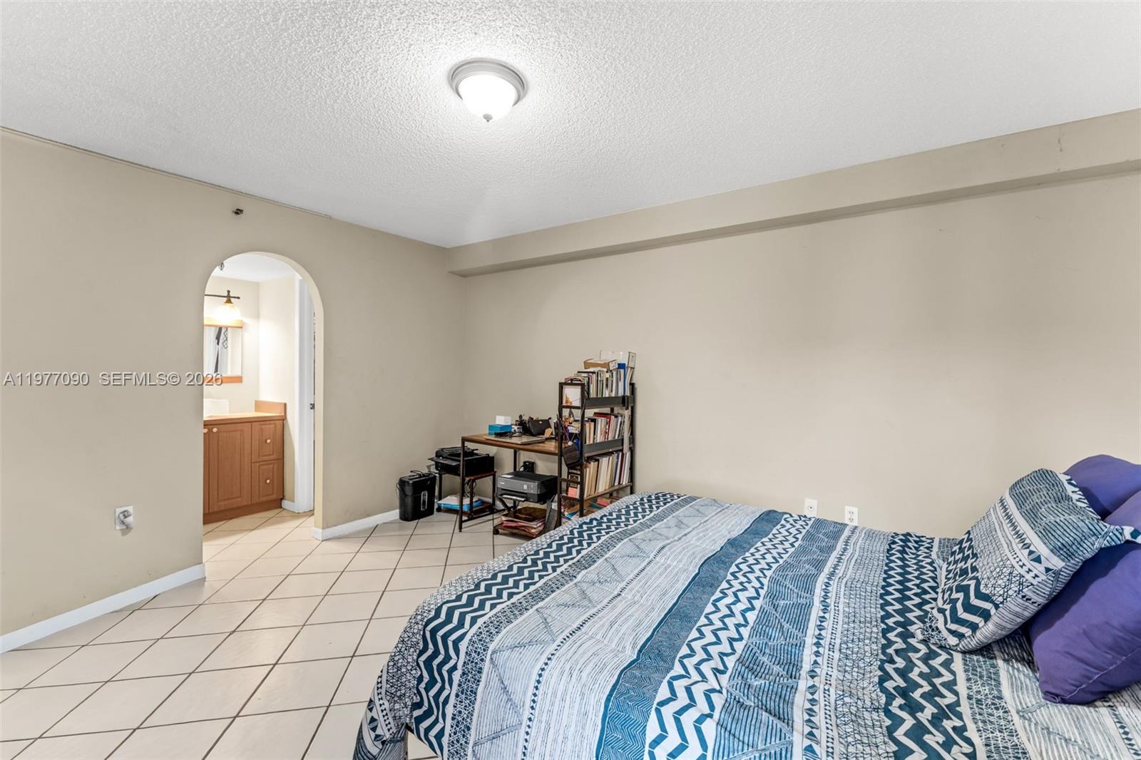 10641 Southwest 108th Avenue, Unit 3D Miami, FL 33176 - Photo 14 of 26 a bedroom with a bed and a chandelier