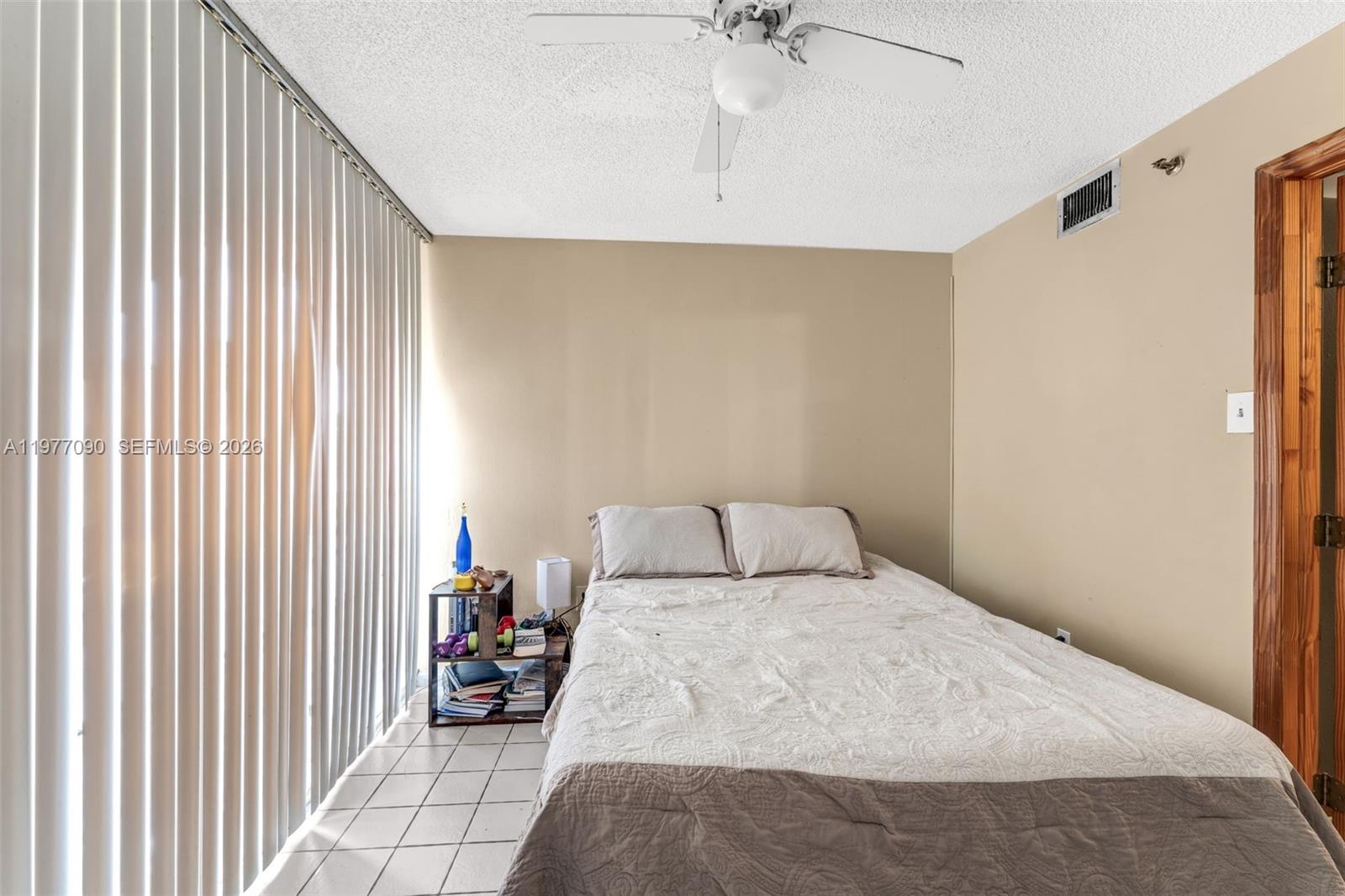 10641 Southwest 108th Avenue, Unit 3D Miami, FL 33176 - Photo 18 of 26 a bedroom with a bed and a chandelier