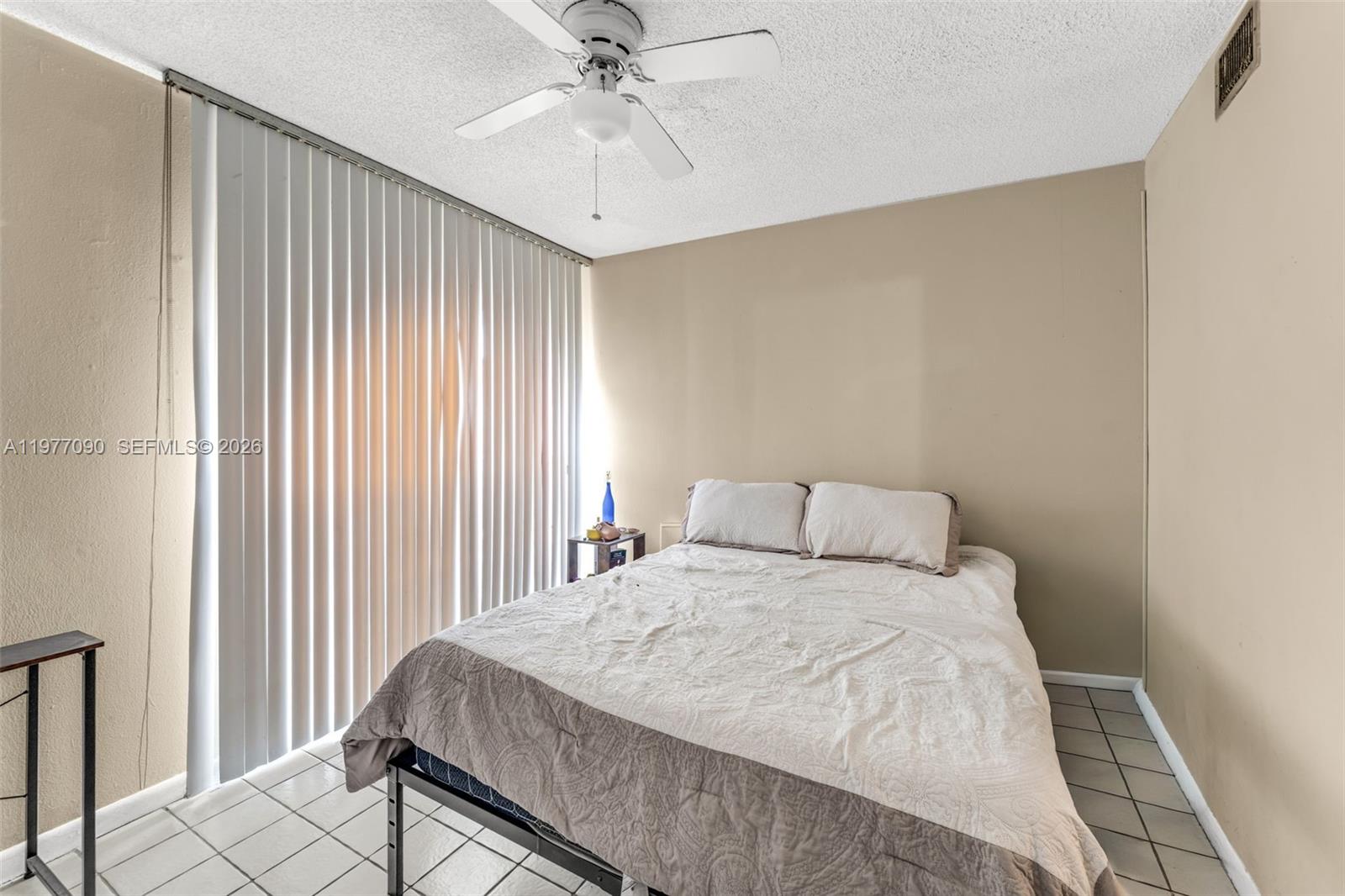 10641 Southwest 108th Avenue, Unit 3D Miami, FL 33176 - Photo 19 of 26 a bedroom with a large bed and a chandelier
