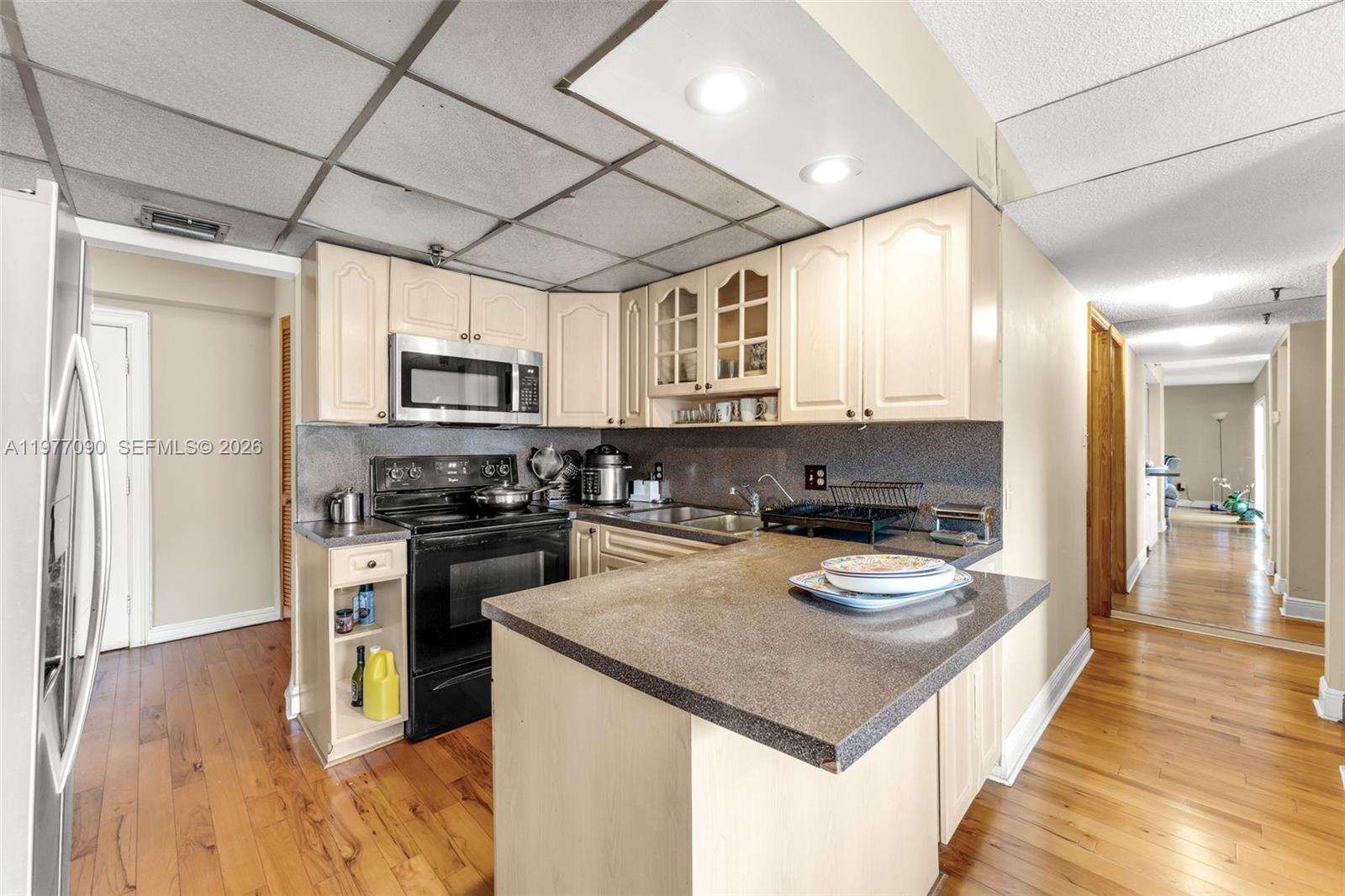 10641 Southwest 108th Avenue, Unit 3D Miami, FL 33176 - Photo 7 of 26 a kitchen with a stove a sink and a refrigerator