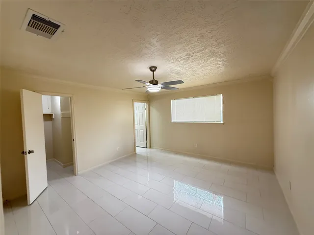 an empty room with fan and windows