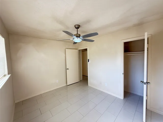 an empty room and chandelier fan