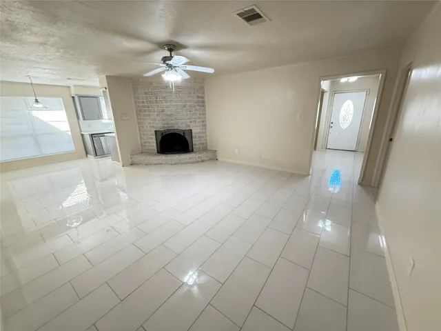 en empty room with windows and fireplace