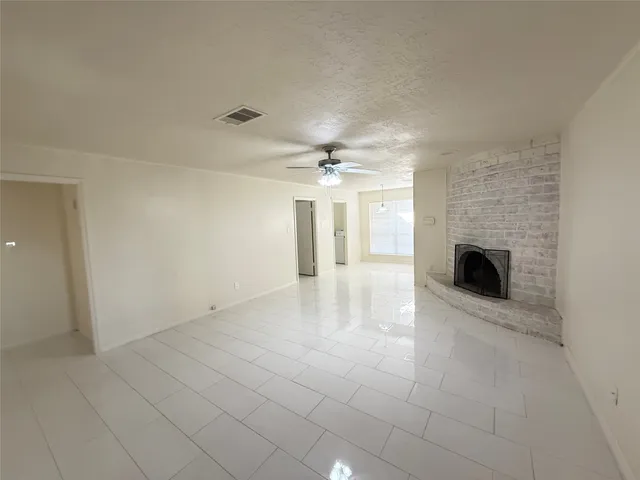 an empty room with fireplace and fan