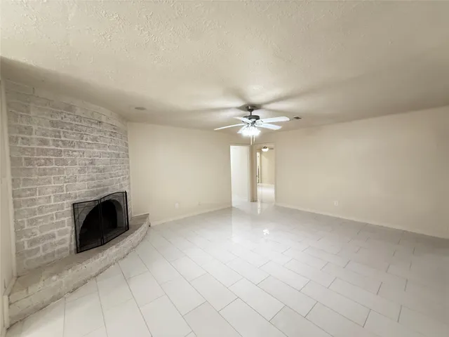 an empty room with windows and fireplace