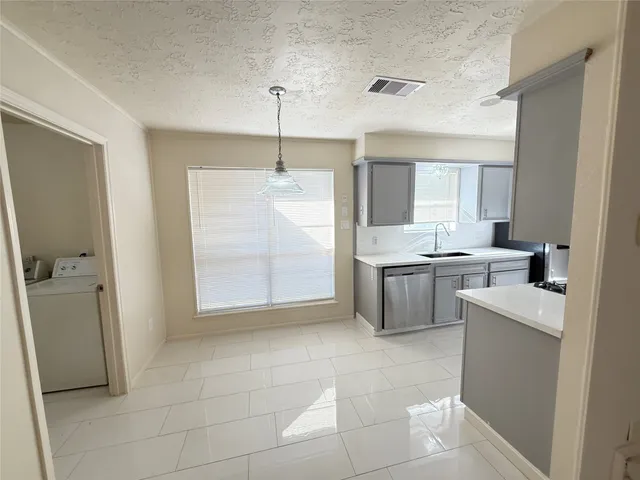 a kitchen with a sink a counter top space cabinets and stainless steel appliances