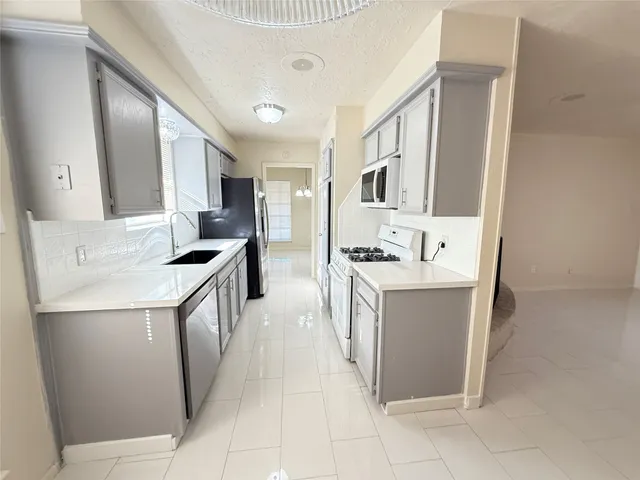 a kitchen with a sink stove and cabinets