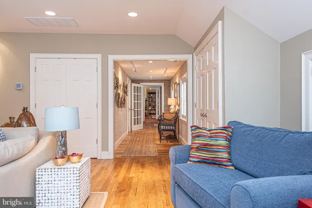 a living room with furniture a flat screen tv and a floor to ceiling window