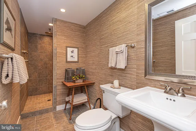 a bathroom with a granite countertop sink a mirror and a shower