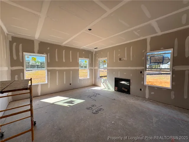 a view of an empty room with a fireplace and a window