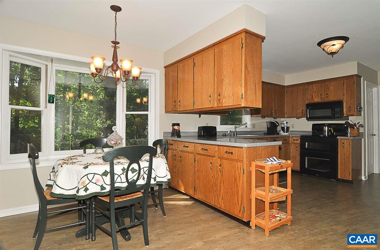 2424 Thrush Road Charlottesville, VA 22901 - Photo 9 of 25 a kitchen with granite countertop a stove a sink a refrigerator and a dining table with garden view