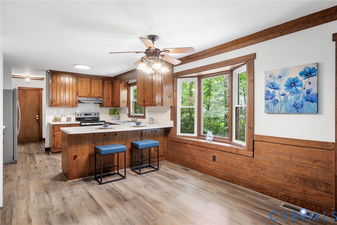3121 Quail Hill Drive Midlothian, VA 23112 - Photo 9 of 37 a kitchen with stainless steel appliances granite countertop a stove a refrigerator a sink a dining table and chairs with wooden floor