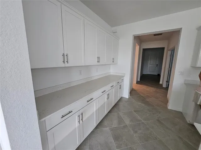 a kitchen with granite countertop white cabinets and sink