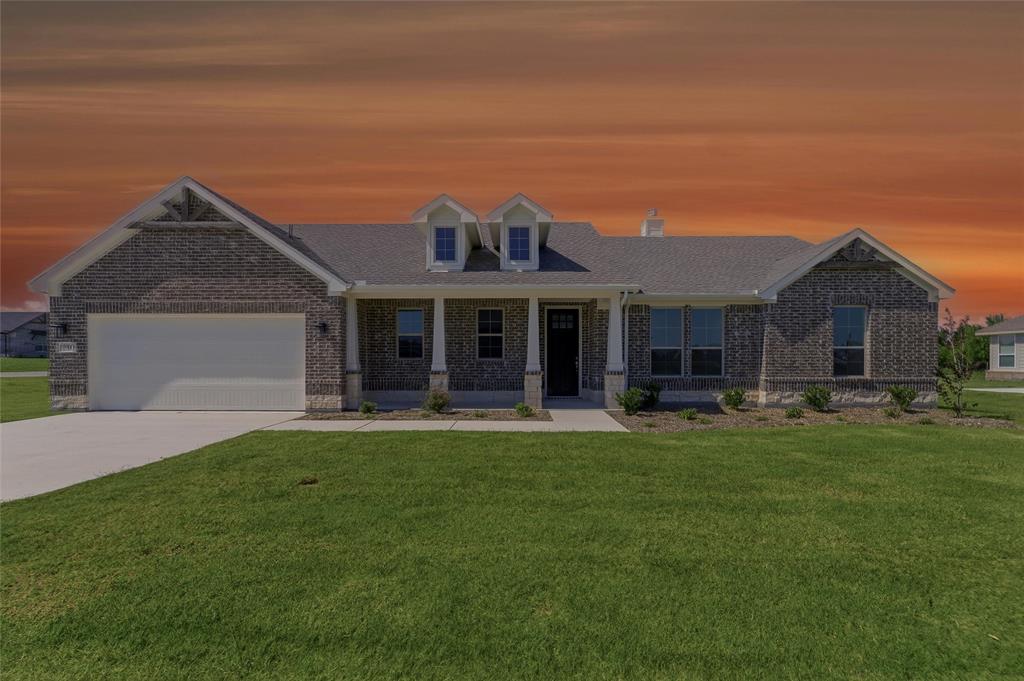 Brick exterior residence with a covered front porch and dormer windows