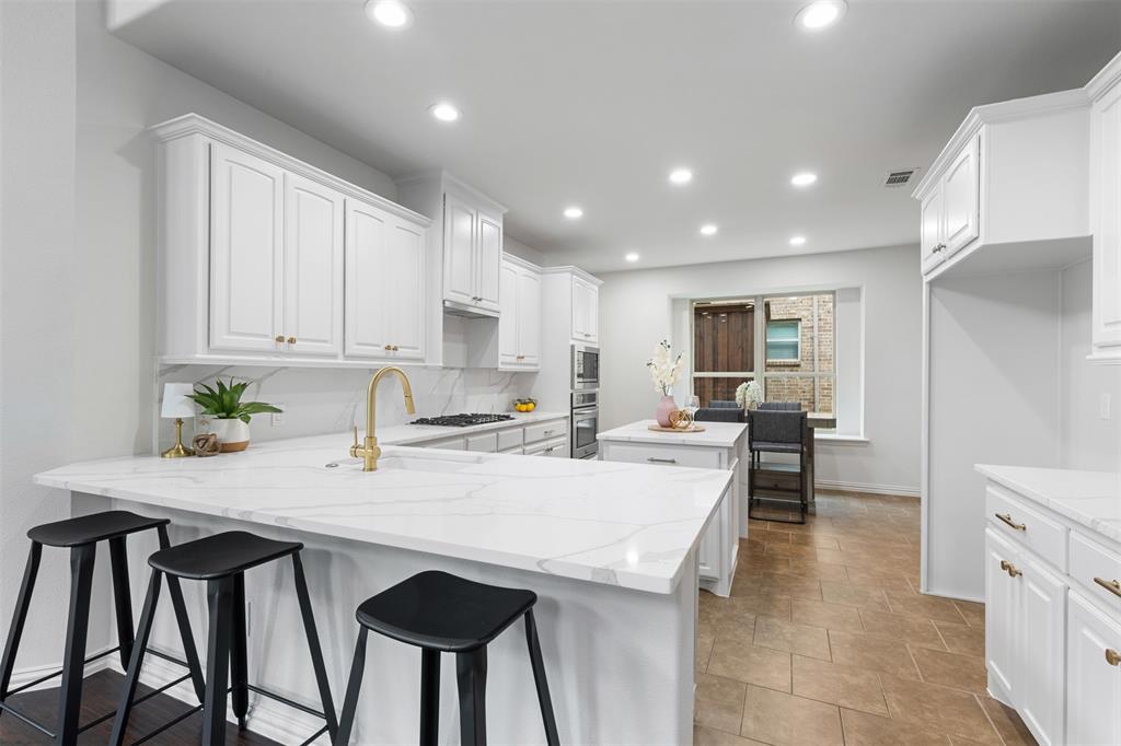 11984 Del Rio Drive Frisco, TX 75035 - Photo 6 of 38 Kitchen featuring oven, white cabinetry, a kitchen island, and a sink
