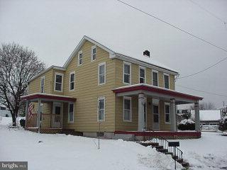 a front view of a house with yard and parking space