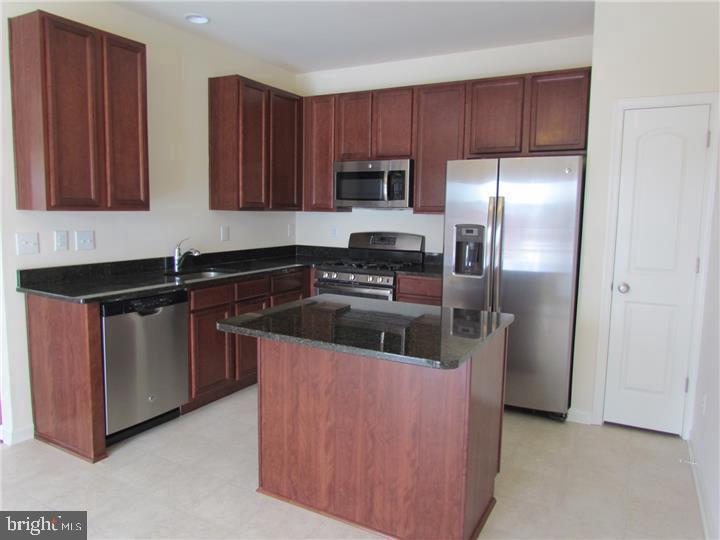 3889 Cephas Child Road, Unit 13 Doylestown, PA 18902 - Photo 12 of 25 a kitchen with stainless steel appliances granite countertop a refrigerator a stove a sink and dishwasher