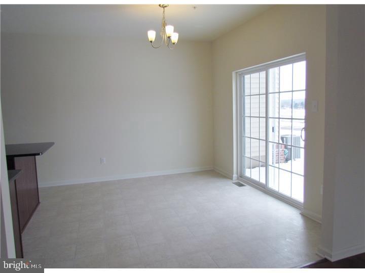 3889 Cephas Child Road, Unit 13 Doylestown, PA 18902 - Photo 15 of 25 an empty room with chandelier fan and windows