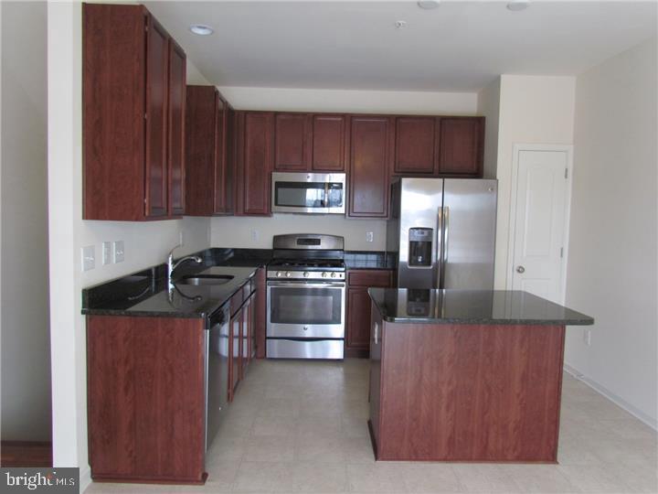 3889 Cephas Child Road, Unit 13 Doylestown, PA 18902 - Photo 9 of 25 a kitchen with stainless steel appliances granite countertop a stove a refrigerator and a sink