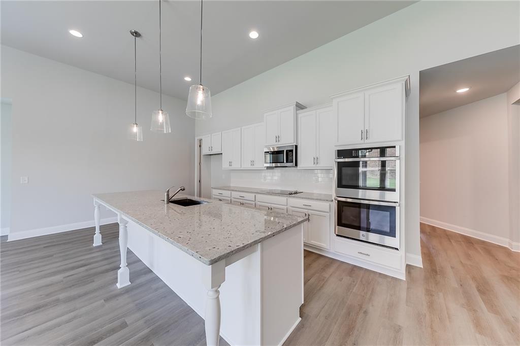 118 Classic Overlook Homer, GA 30547 - Photo 13 of 42 a kitchen with stainless steel appliances granite countertop a sink a microwave oven a refrigerator and white cabinets with wooden floor