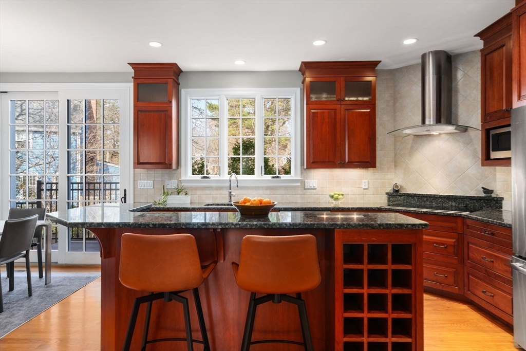 22 Oakencroft Road Wellesley, MA 02482 - Photo 14 of 40 a kitchen with granite countertop a table chairs sink and cabinets