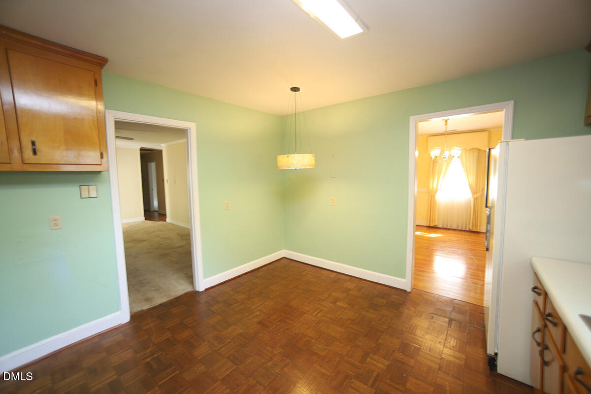 3518 Randolph Road Durham, NC 27705 - Photo 21 of 32 a view of an empty room with wooden floor and a kitchen