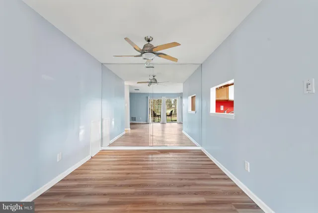 a view of a hallway with wooden floor and a chandelier
