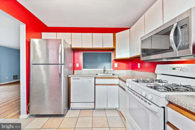 a kitchen with stainless steel appliances granite countertop a stove a refrigerator and a stove