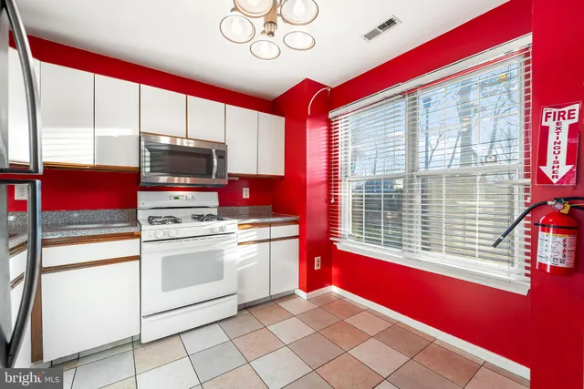 a kitchen with stainless steel appliances kitchen island granite countertop a stove a sink and a refrigerator