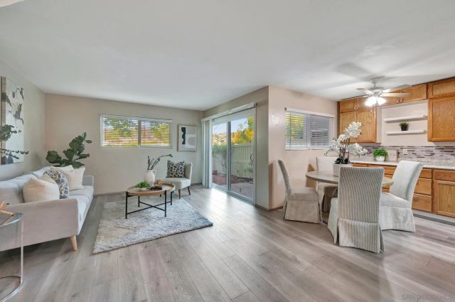 a living room with furniture a wooden floor and a large window