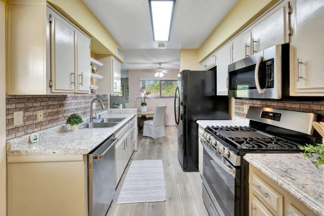 a kitchen with stainless steel appliances granite countertop a sink stove and refrigerator