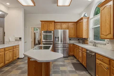 a kitchen with stainless steel appliances a sink cabinets and refrigerator