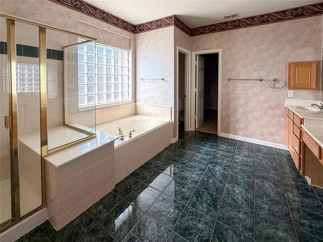 a bathroom with a tub sink and mirror