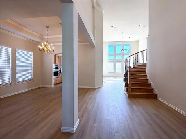 a view of a hallway with wooden floor and staircase