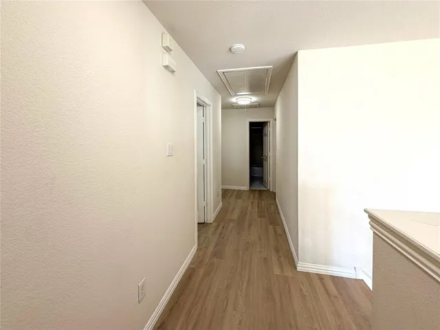 a view of a hallway with wooden floor