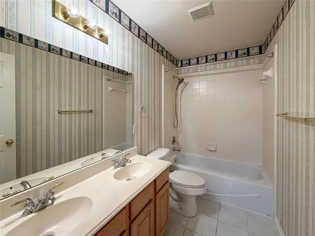 a bathroom with a double vanity sink toilet mirror and shower
