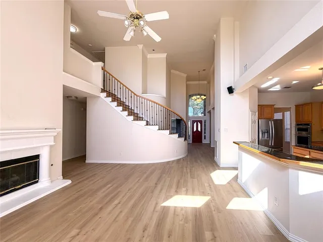a view of a hallway with wooden floor staircase and a kitchen