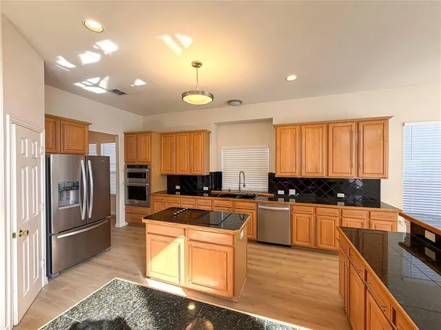 a kitchen with stainless steel appliances granite countertop a sink stove and refrigerator