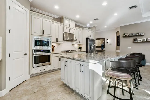 a living room with furniture kitchen view and a chandelier