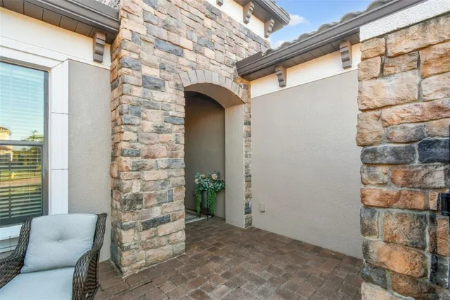 a view of a patio with couple of chairs and a potted plant