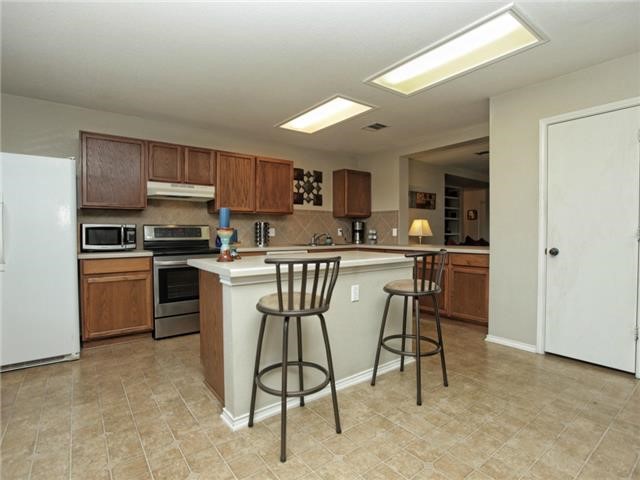 1008 Apollo Circle Round Rock, TX 78664 - Photo 14 of 33 a kitchen with a sink stainless steel appliances and cabinets