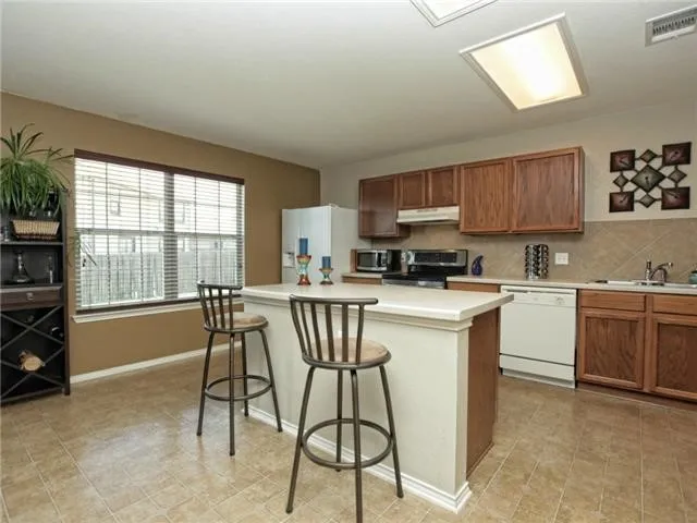a kitchen with a stove a sink cabinets and a dining table