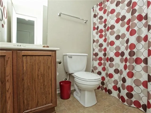 a bathroom with a toilet and a shower curtain